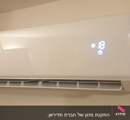 מזגן קיר לבן עם תצוגת טמפרטורה דיגיטלית
